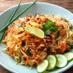 Pad Thaï au poulet avec nouilles de riz, cacahuètes, citron vert et légumes croquants