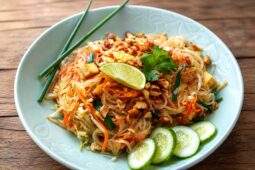 Pad Thaï au poulet avec nouilles de riz, cacahuètes, citron vert et légumes croquants
