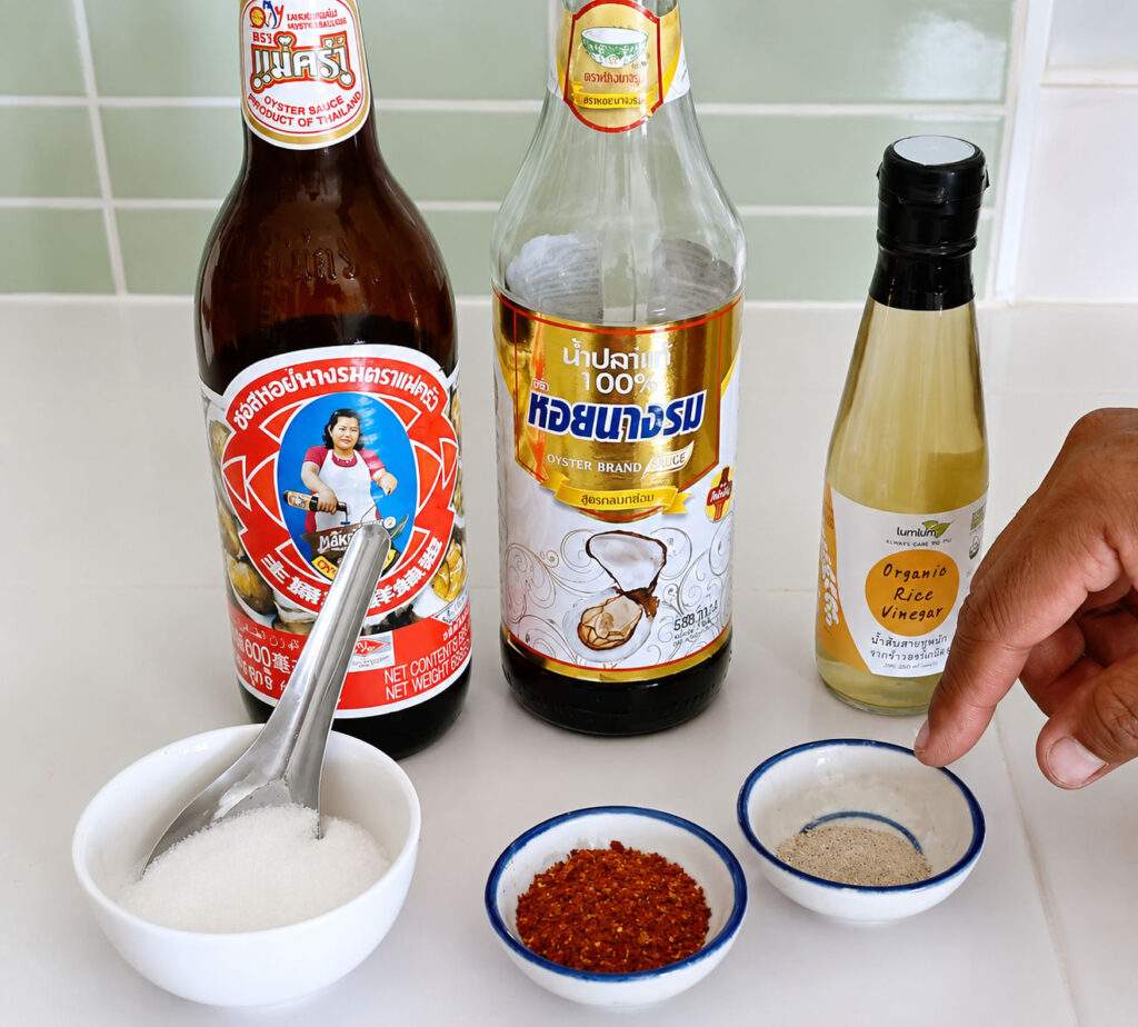 Ingrédients et sauces nécessaires pour préparer un Pad See Ew traditionnel.