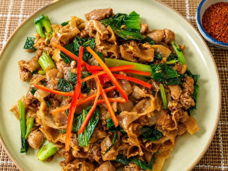 Pad See Ew, nouilles de riz sautées thaïlandaises au poulet, brocoli chinois et sauce soja foncée.