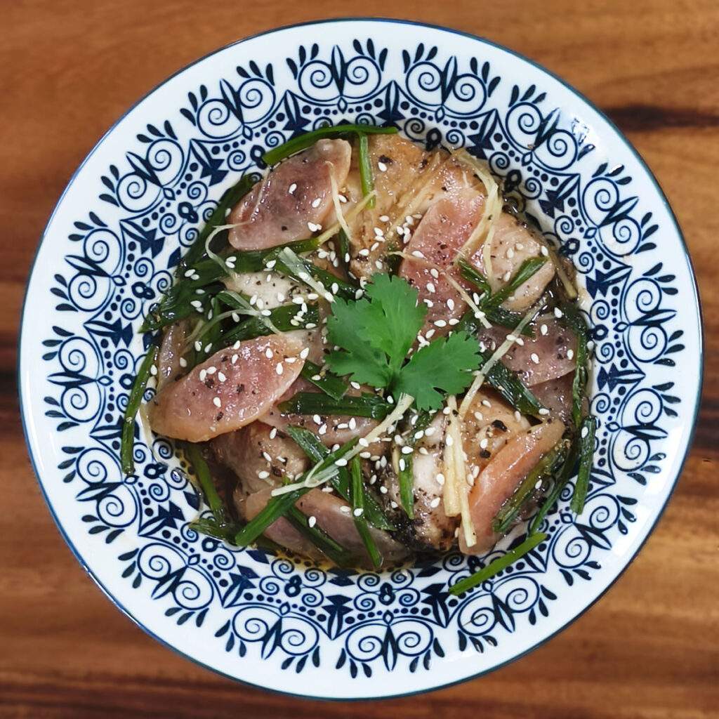 Plat de poulet vapeur au gingembre, saucisse chinoise et ciboules servi chaud avec son jus parfumé