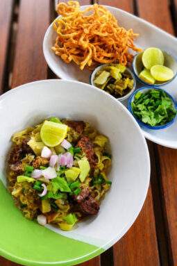 Khao Soi au bœuf avec nouilles croustillantes, citron vert, coriandre et légumes marinés