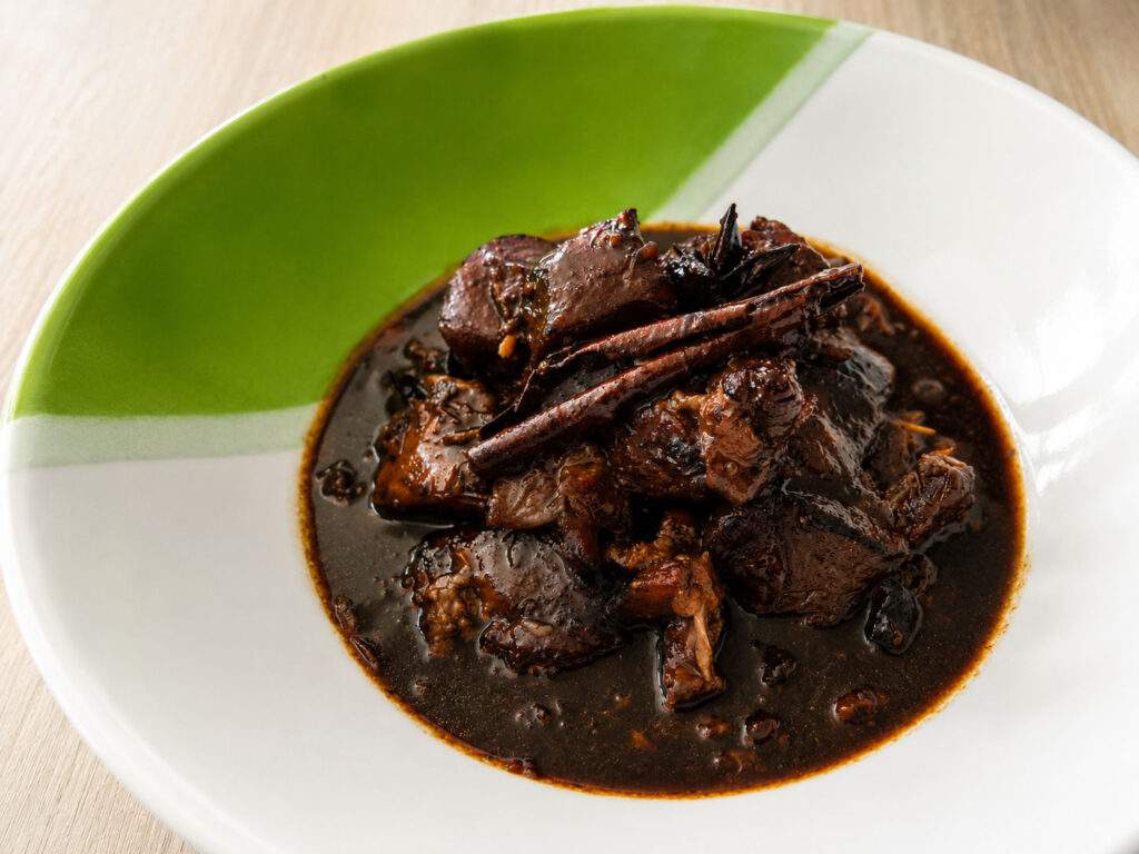 Assiette de Moo Hong Som, porc braisé thaïlandais à la sauce soja et au tamarin servi dans une sauce riche et parfumée.