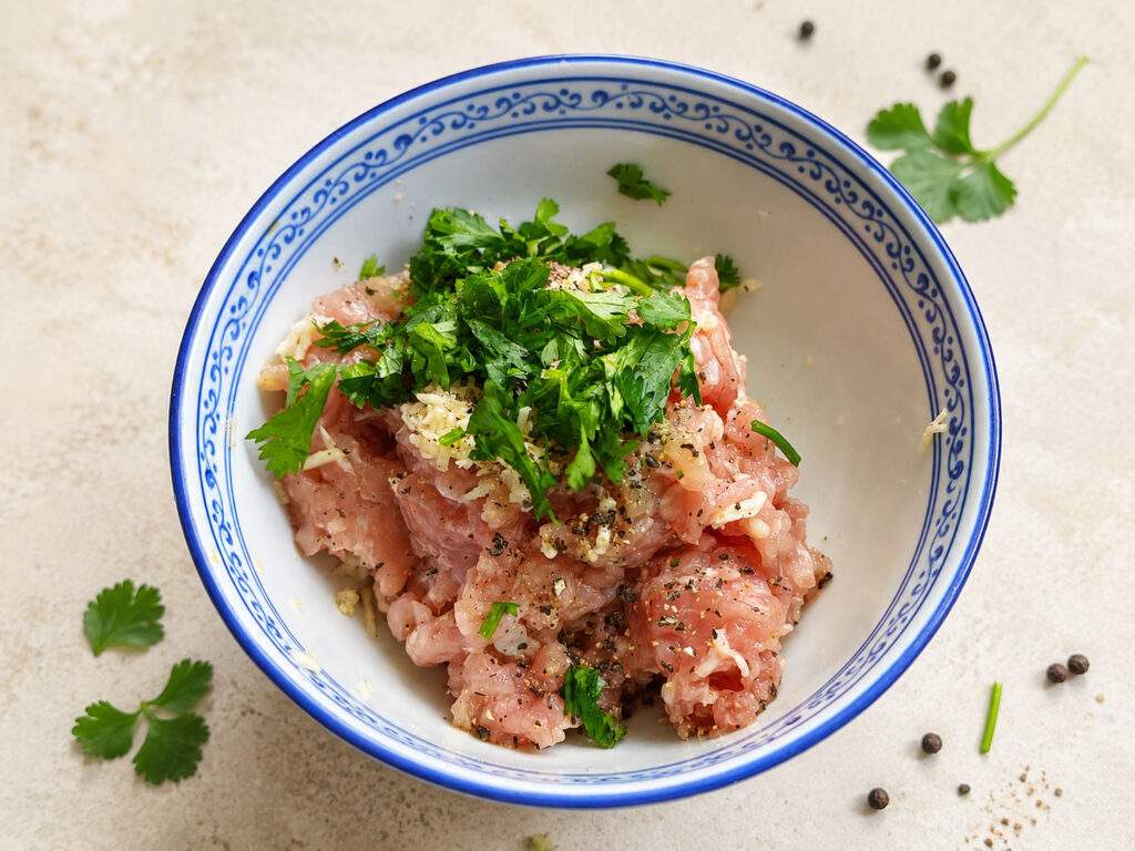 Préparation des boulettes de poulet assaisonnées pour le Khao Tom thaïlandais