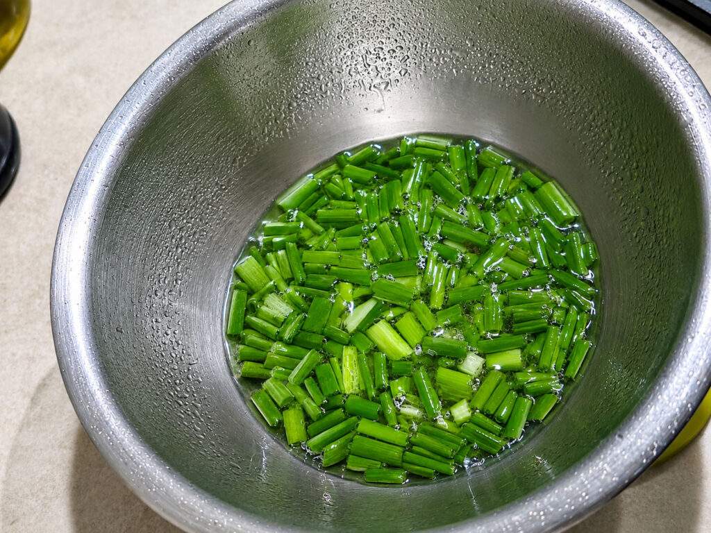 Ciboule fraîche dans de l'eau glacée pour garnir un Khao Tom