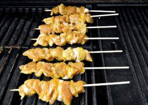 Brochettes de poulet thaïes en cuisson sur un barbecue