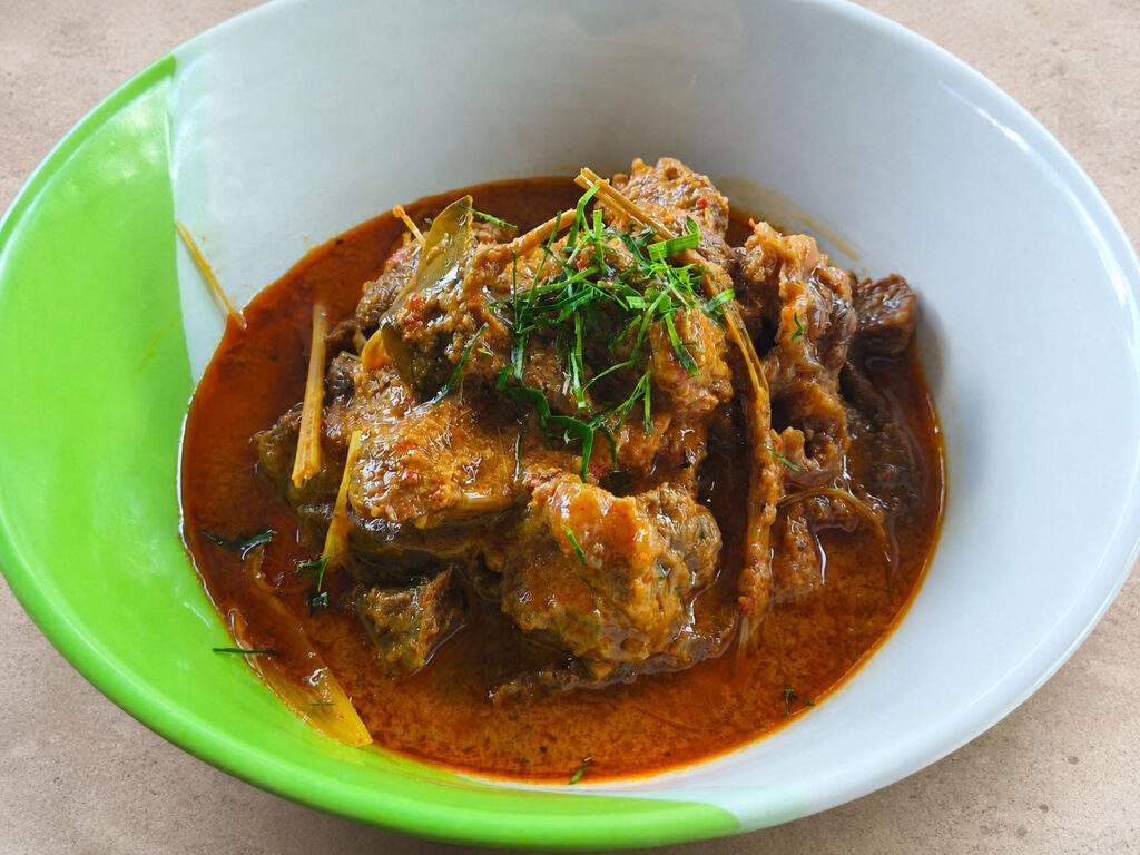 Gros plan sur un bœuf rendang garni de feuilles de combava